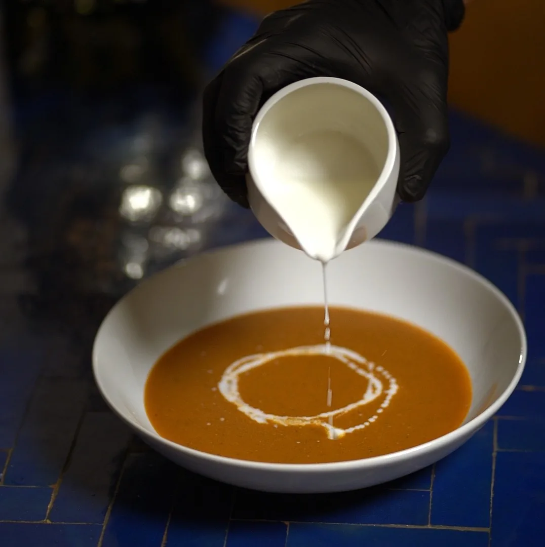 Sirviendo un chorro de nata sobre una crema de temporada