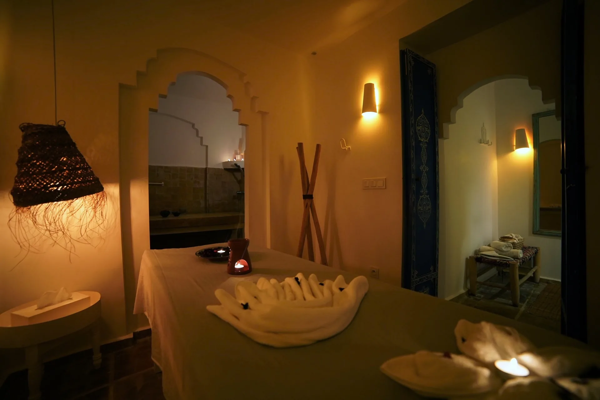 Sala de masaje del hammam con toallas decorativas y velas encendidas